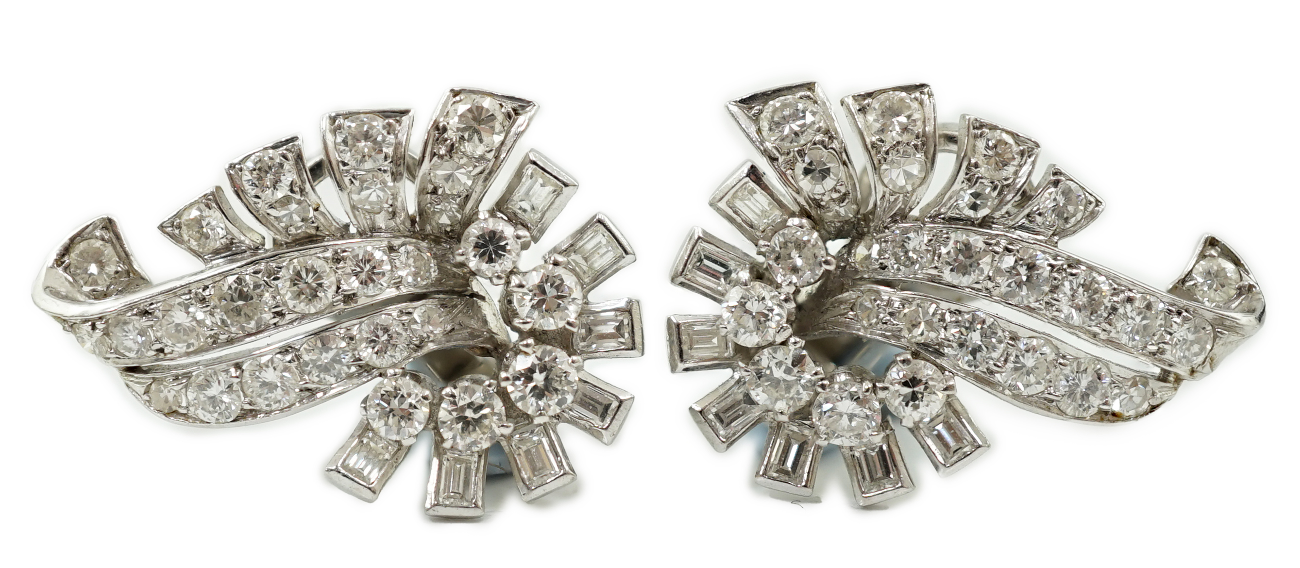 A pair of platinum and diamond cluster scroll ear clips